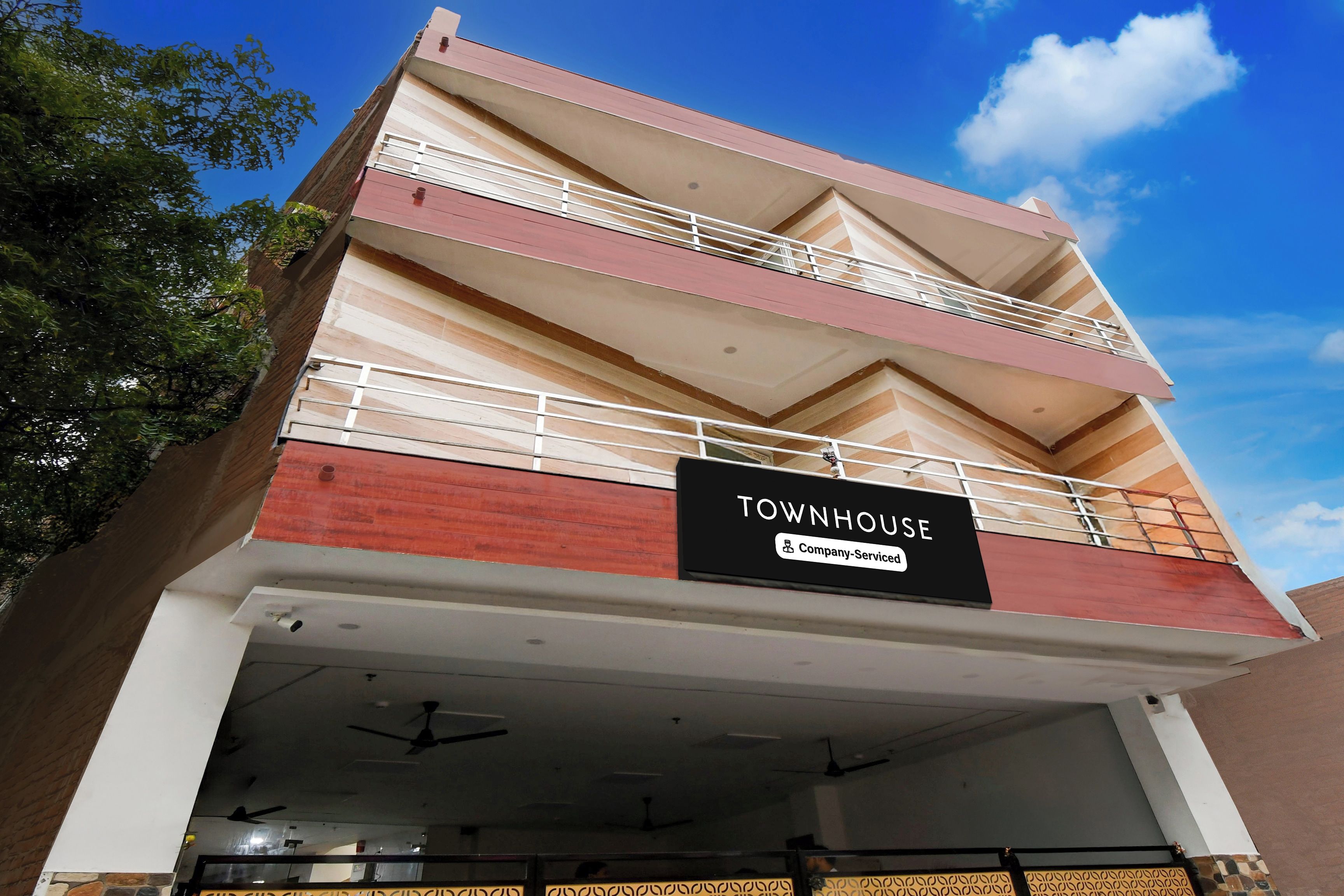 A multi-story building with a sign indicating it is a company-serviced townhouse.
