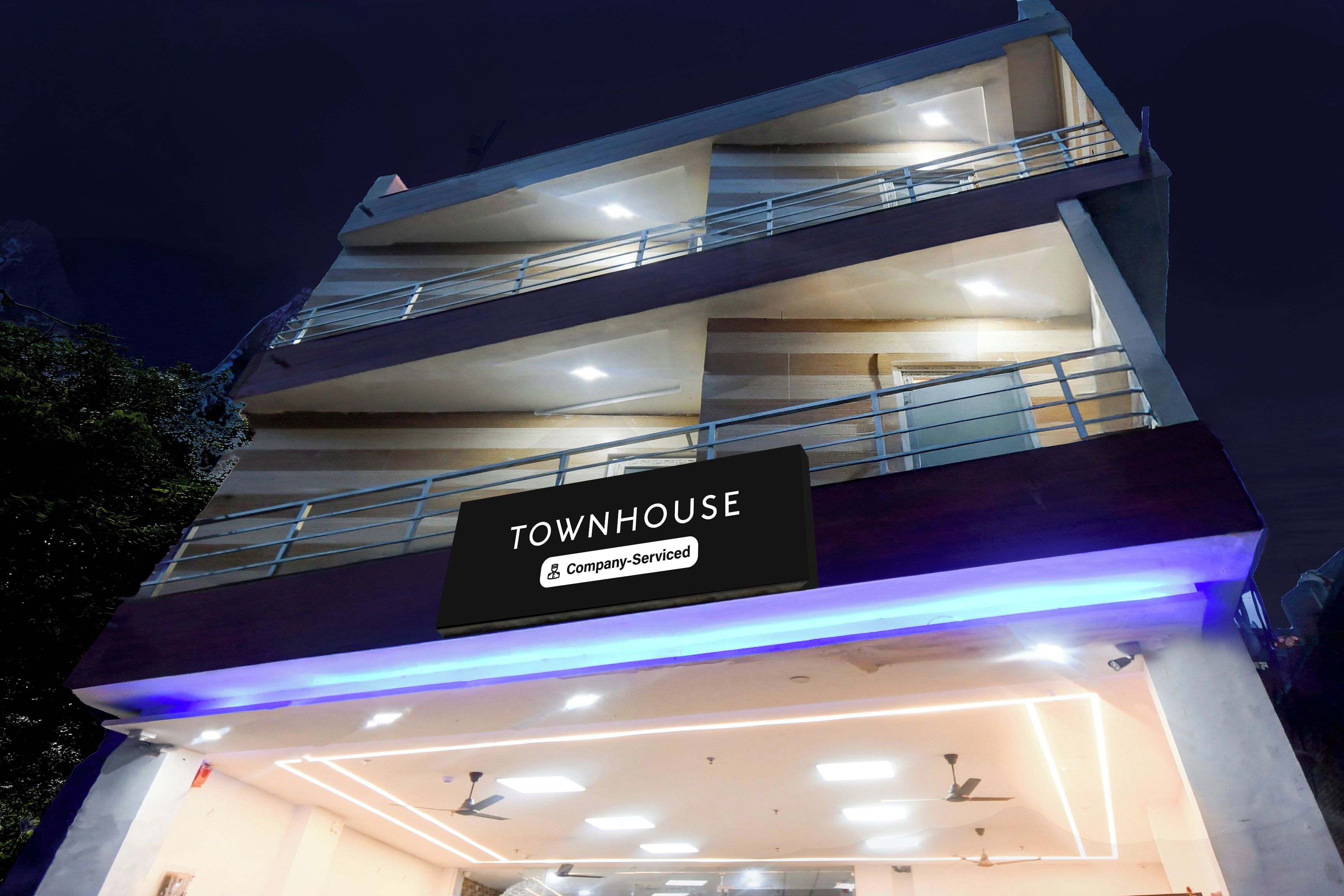 Un edificio de varios pisos con un letrero que dice 'TOWNHOUSE Company-Serviced'.