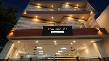 Un edificio de varios pisos con un letrero que dice 'TOWNHOUSE Company-Serviced'.