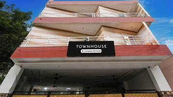 A multi-story building with a sign reading 'TOWNHOUSE' and a 'Company-Serviced' label.