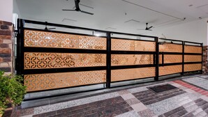 Corredor com painéis decorativos estampados, ventilador de teto e chão de azulejos.