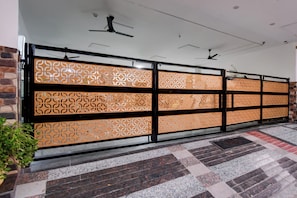 Un pasillo con paneles decorativos estampados, un ventilador de techo y piso de baldosas.