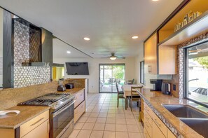 A modern kitchen with a gas stove, a built-in oven, and a coffee maker. - Indio Paradise: 4-Bedroom Home w/ Resort-Like Pool (Indio)
