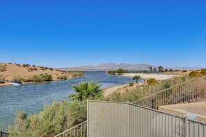 Ein Fluss mit einem Boot, ein Sandstrand und Berge in der Ferne.