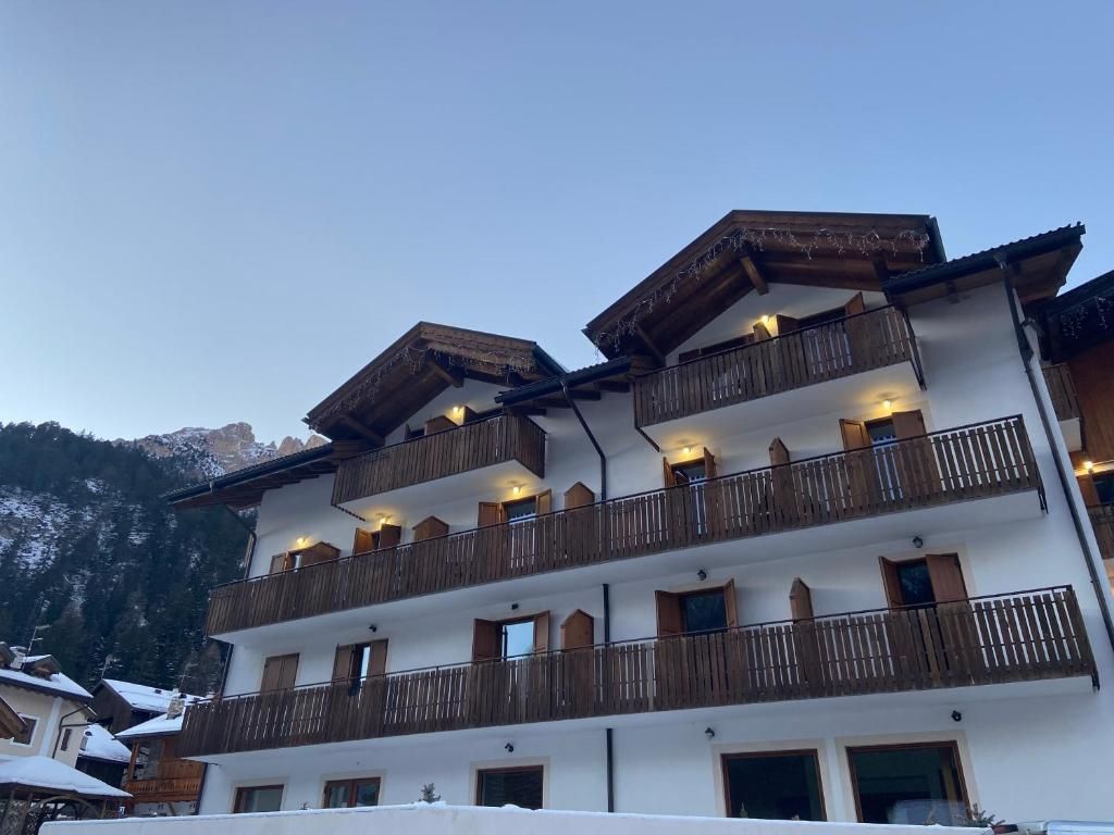 Ein mehrstöckiges Gebäude mit Balkonen, vermutlich ein Hotel oder Resort, vor einer Bergkulisse.