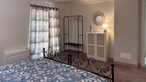 Quarto com cama, guarda-roupa, espelho e radiador.