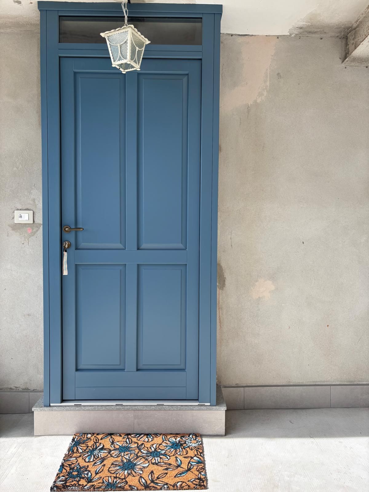 A blue door with a keyhole and a doorbell.