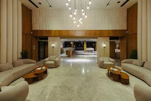 A spacious lobby with a high ceiling, multiple seating areas, and a central open space. - Arena Beach Resort & Spa (Hurghada)
