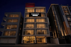Un hotel de varios pisos con un letrero llamativo que dice 'TOWNHOUSE Company Serviced'.