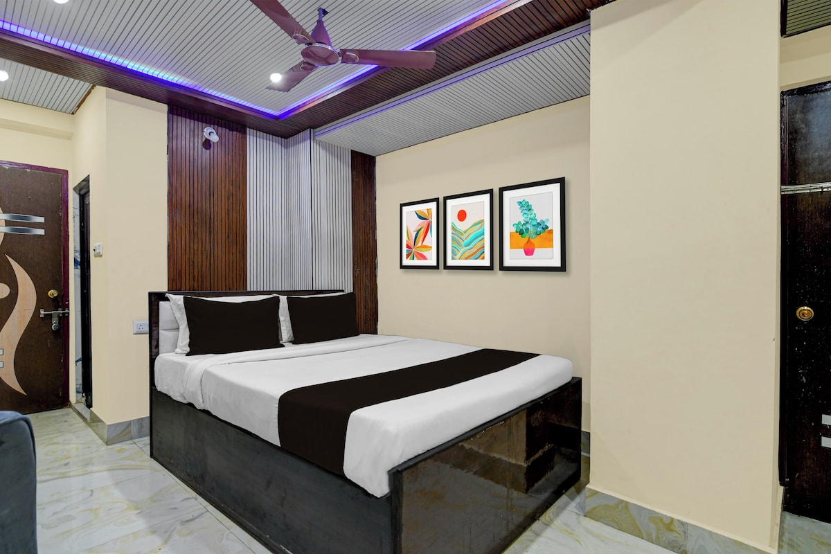 Una habitación de hotel con una cama, un ventilador de techo y tres obras de arte enmarcadas en la pared.