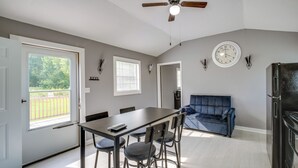 Eine moderne Küche mit Essbereich, Deckenventilator, einer Uhr und einem Kühlschrank.