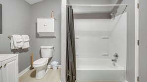 Ein Badezimmer mit Toilette, Badewanne, Dusche und einem Schrank.