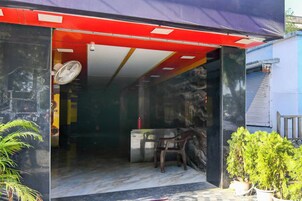 A room with a red awning, a fan, a chair, and a small table.