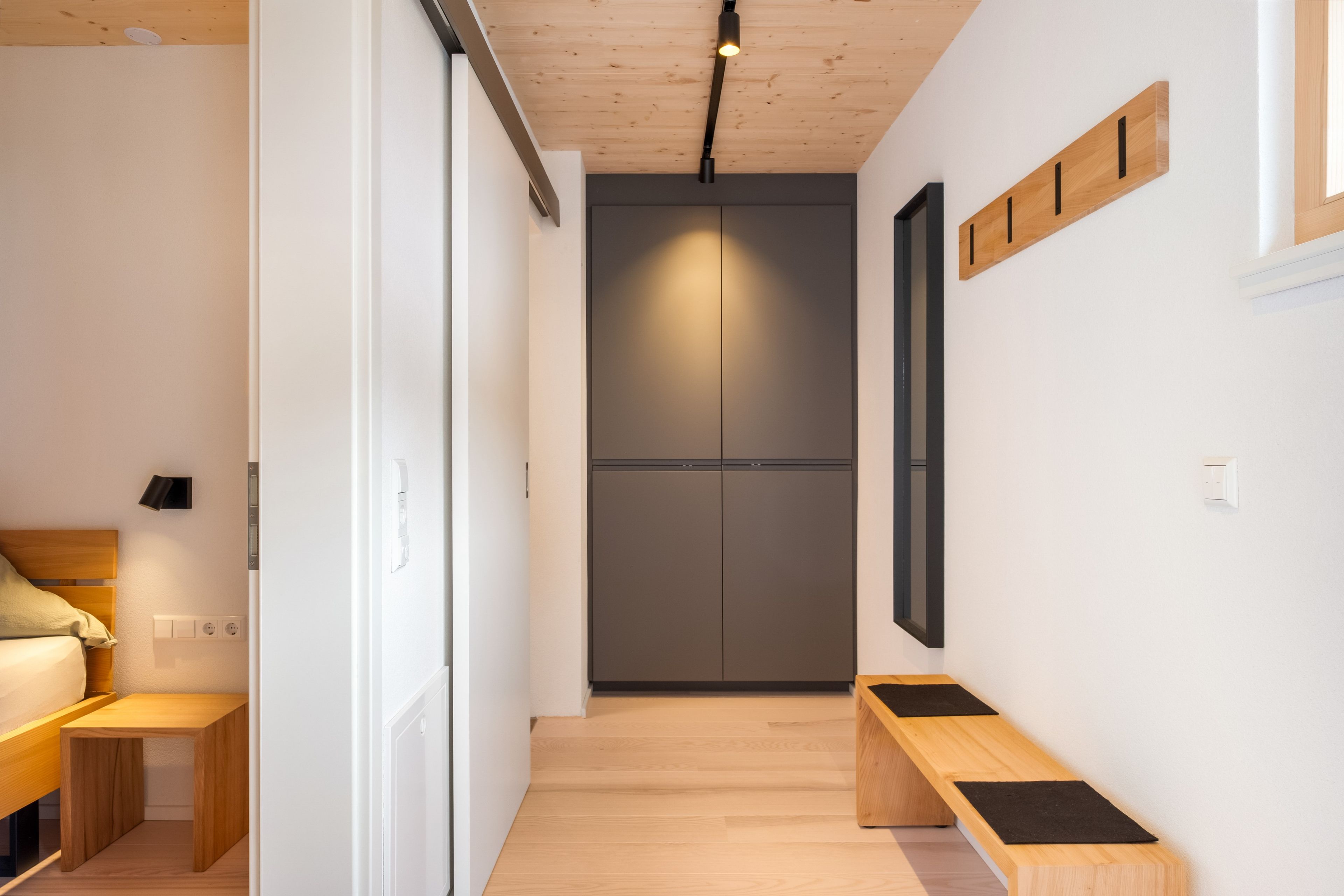 Ein modernes Schlafzimmer mit Bett, Nachttisch und Kleiderschrank.