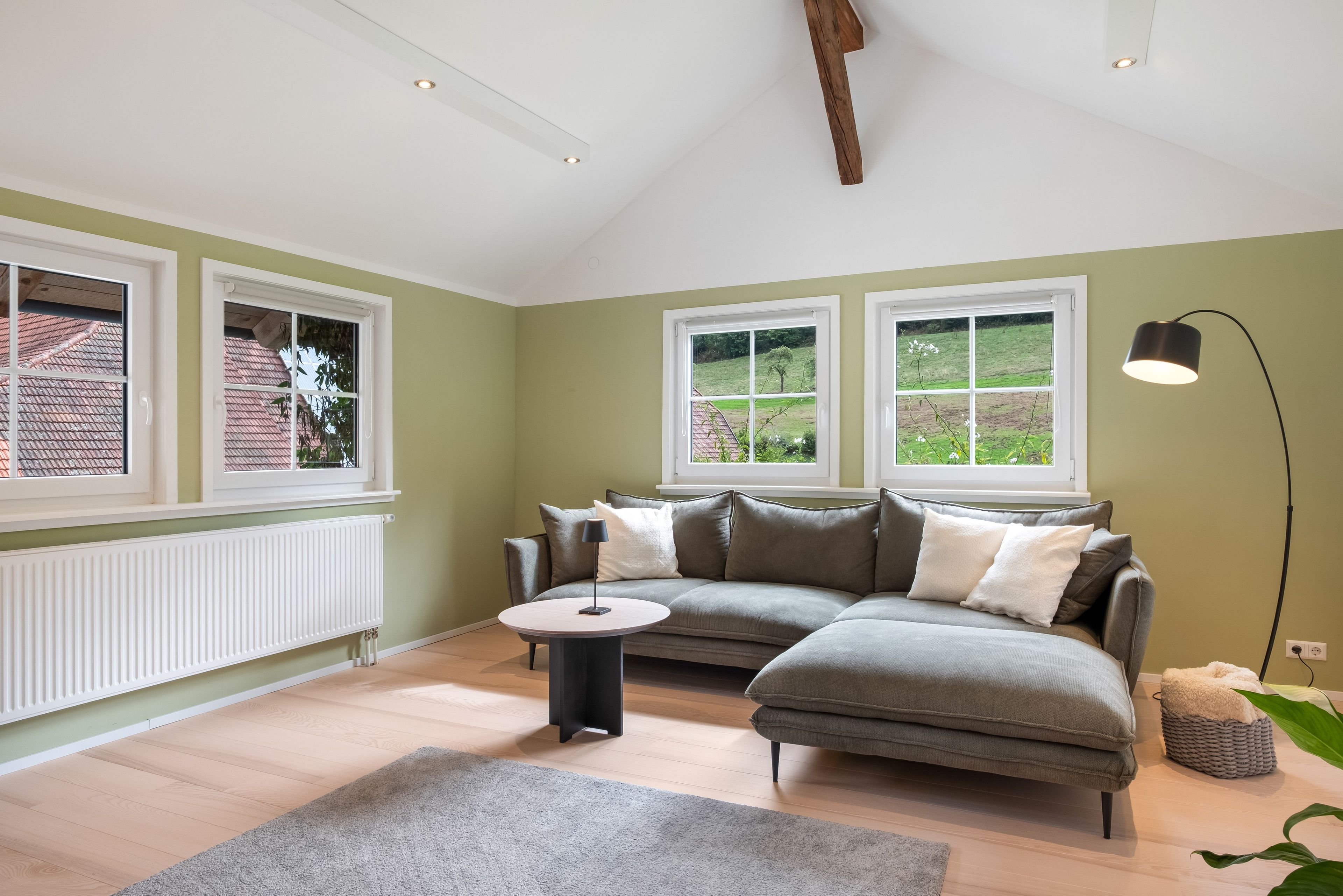A modern living room with a sectional sofa, a round coffee table, and a floor lamp.