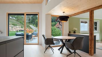 Una cocina moderna con comedor, ventanas amplias y vistas al exterior.