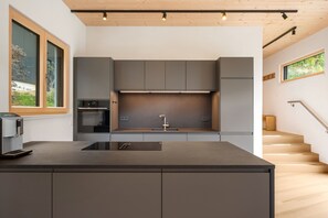 A modern kitchen with a central island, built-in appliances, and a view of the outdoors.