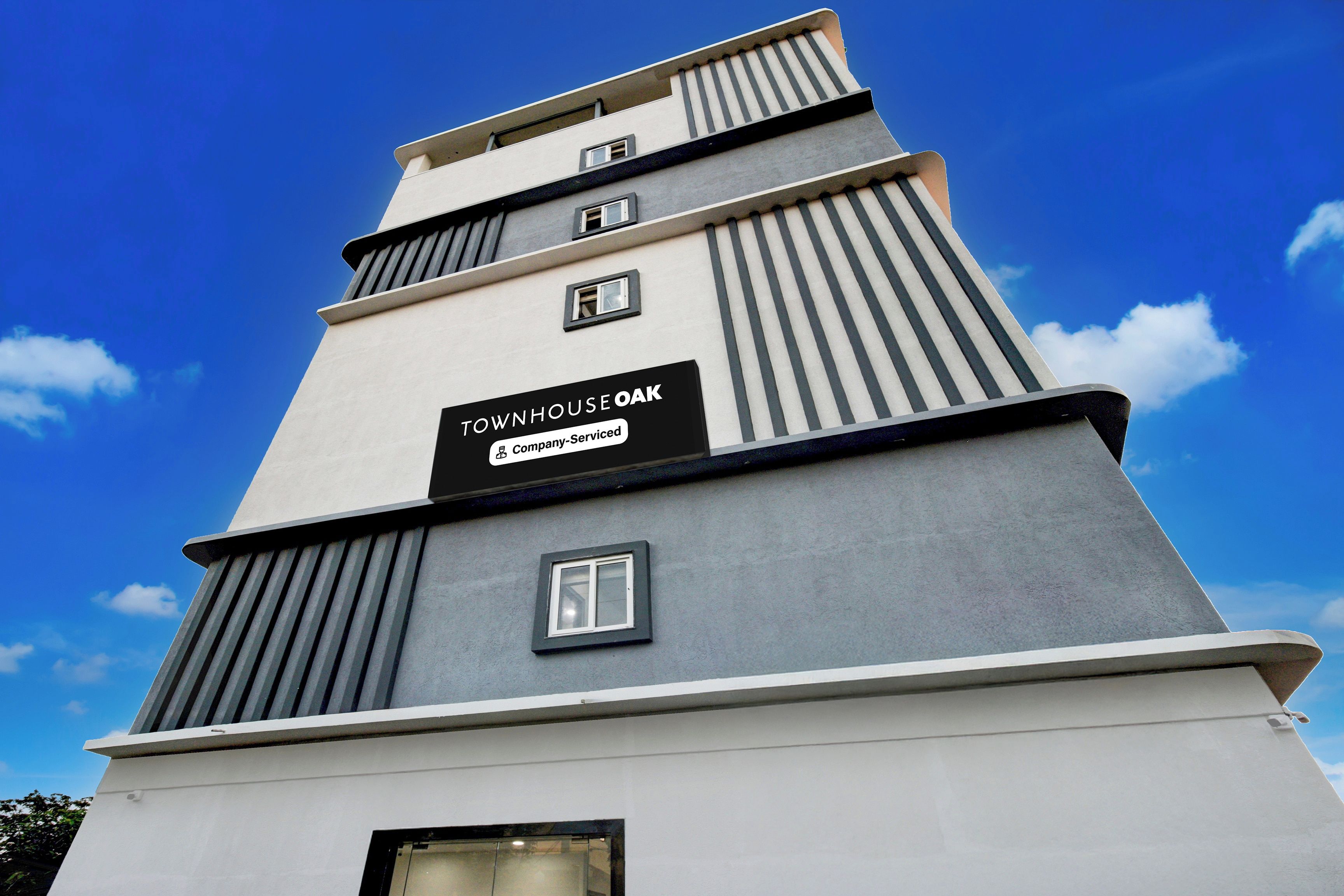 Un edificio de varios pisos con un letrero que indica que es una casa adosada de servicios para empresa.