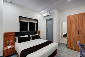 A hotel room with a bed, a wardrobe, a desk, and a window. - Townhouse Oak L B Nagar Metro Station (Hyderabad)