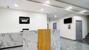Ein Empfangstresen mit Marmorplatte, einer Holzwand und einem Schild mit der Aufschrift 'Company-Serviced'.
