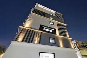 Un edificio de varios pisos con un letrero que indica 'TOURN HOUSE OAK' y 'Empresa con Servicios'.
