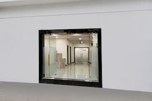 A hallway with a glass door leading to a room, a ceiling fan, and a sign indicating a restaurant. - Townhouse Oak L B Nagar Metro Station (Hyderabad)