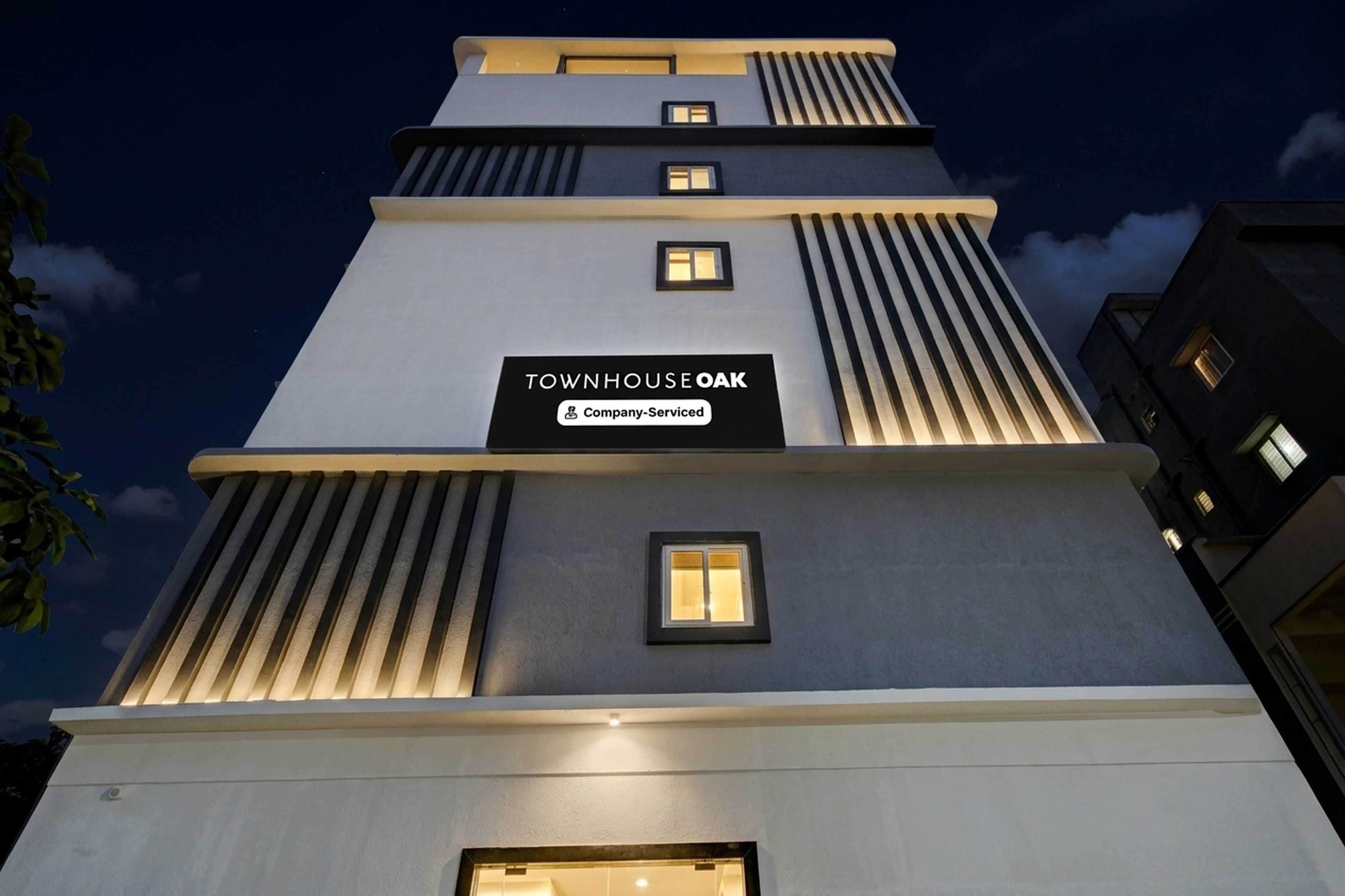 A multi-story building with a sign reading 'TOWNHOUSE OAK Company-Serviced'.