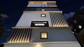 A multi-story building with a sign reading 'TOWNHOUSE OAK Company-Serviced'.