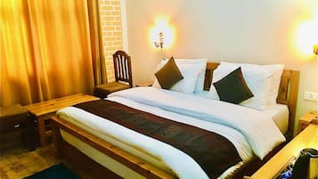 Una habitación de hotel con una cama de madera, una mesita de noche, una silla y una lámpara.