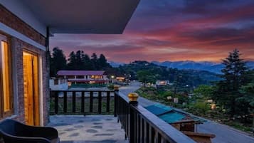 A balcony with a view of a mountain range at dusk.