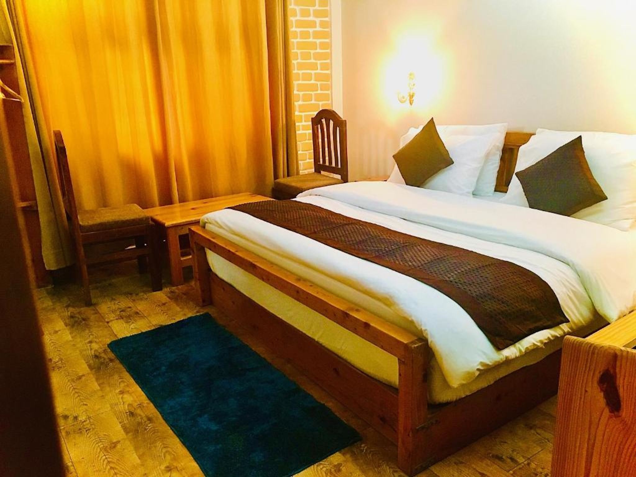 Un dormitorio con cama de madera, un escritorio y una silla.