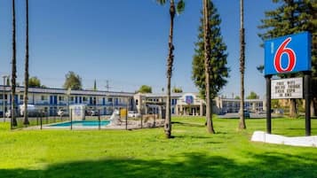 Un motel doté d’une piscine, d’un panneau indiquant que le Wi-Fi est gratuit, d’un mini-réfrigérateur et proposant les chaînes HBO et ESPN dans chaque chambre.
