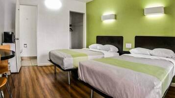 A hotel room with two beds, a desk, and a chair.