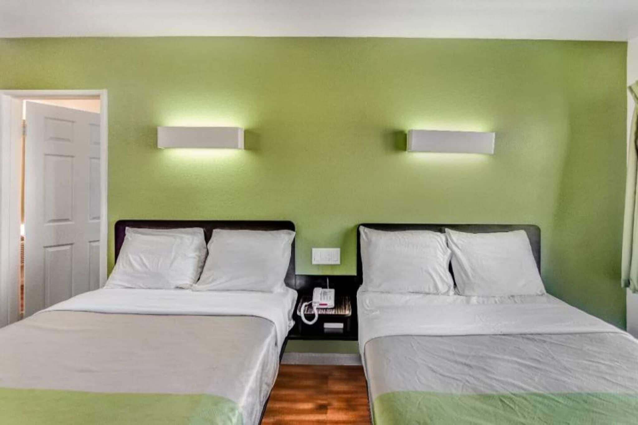 Une chambre double avec deux lits, une table de chevet et une porte.