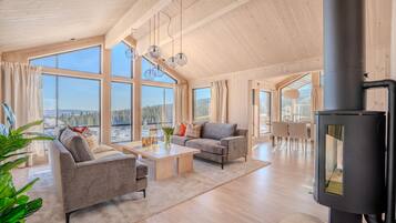 A spacious living room with a large window, a fireplace, and a dining area.