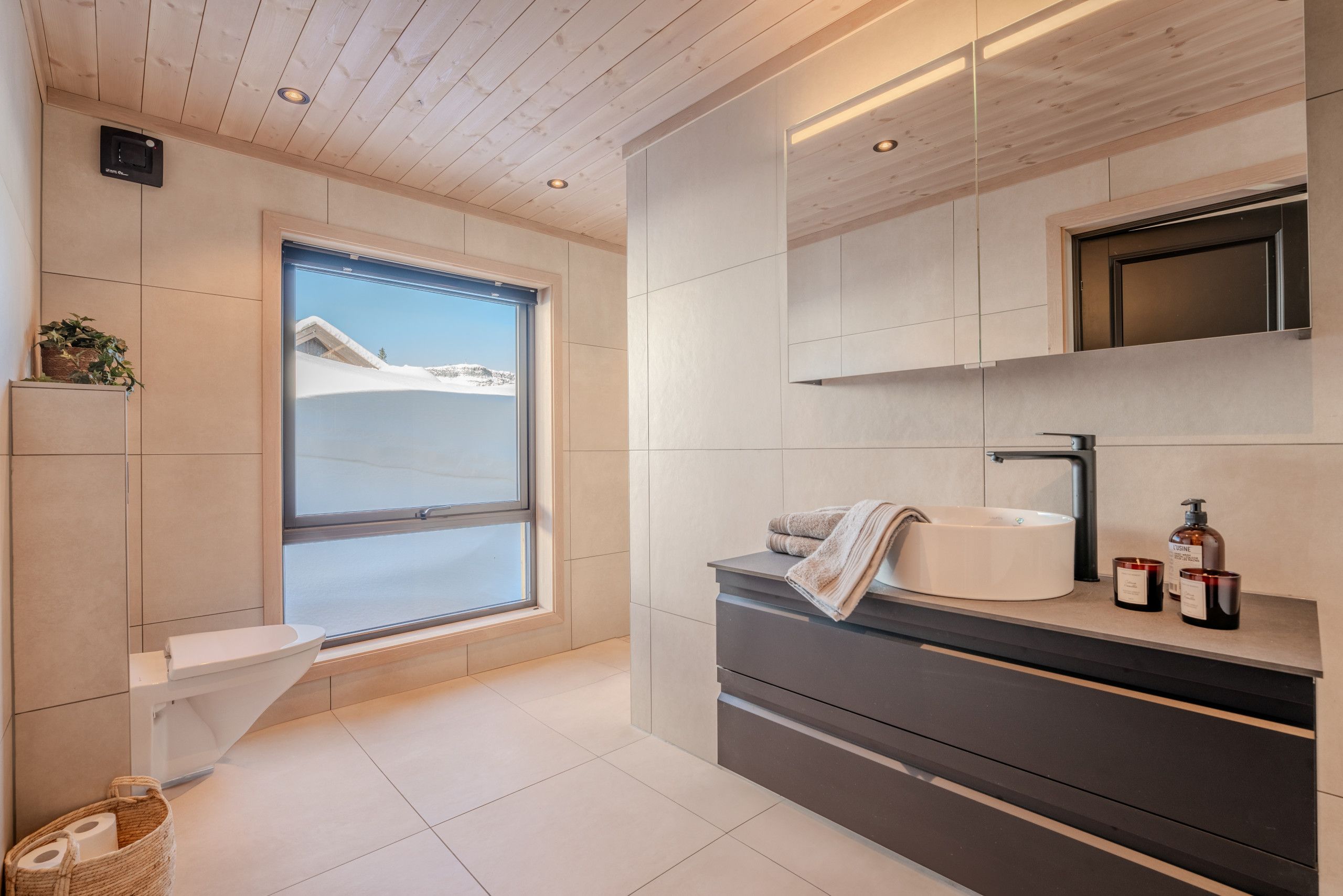 Un baño moderno con inodoro, lavabo y ventana.