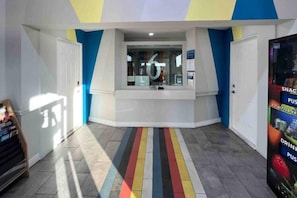 Ein helles Interieur mit einem Streifenboden, einem Empfangstresen und einer Verkaufsmaschine.