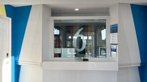 A reception desk with a large number 6 sign, a glass window, and a blue and white wall design. - 2 Full Beds | Non-Smoking, Kitchen (Phoenix)