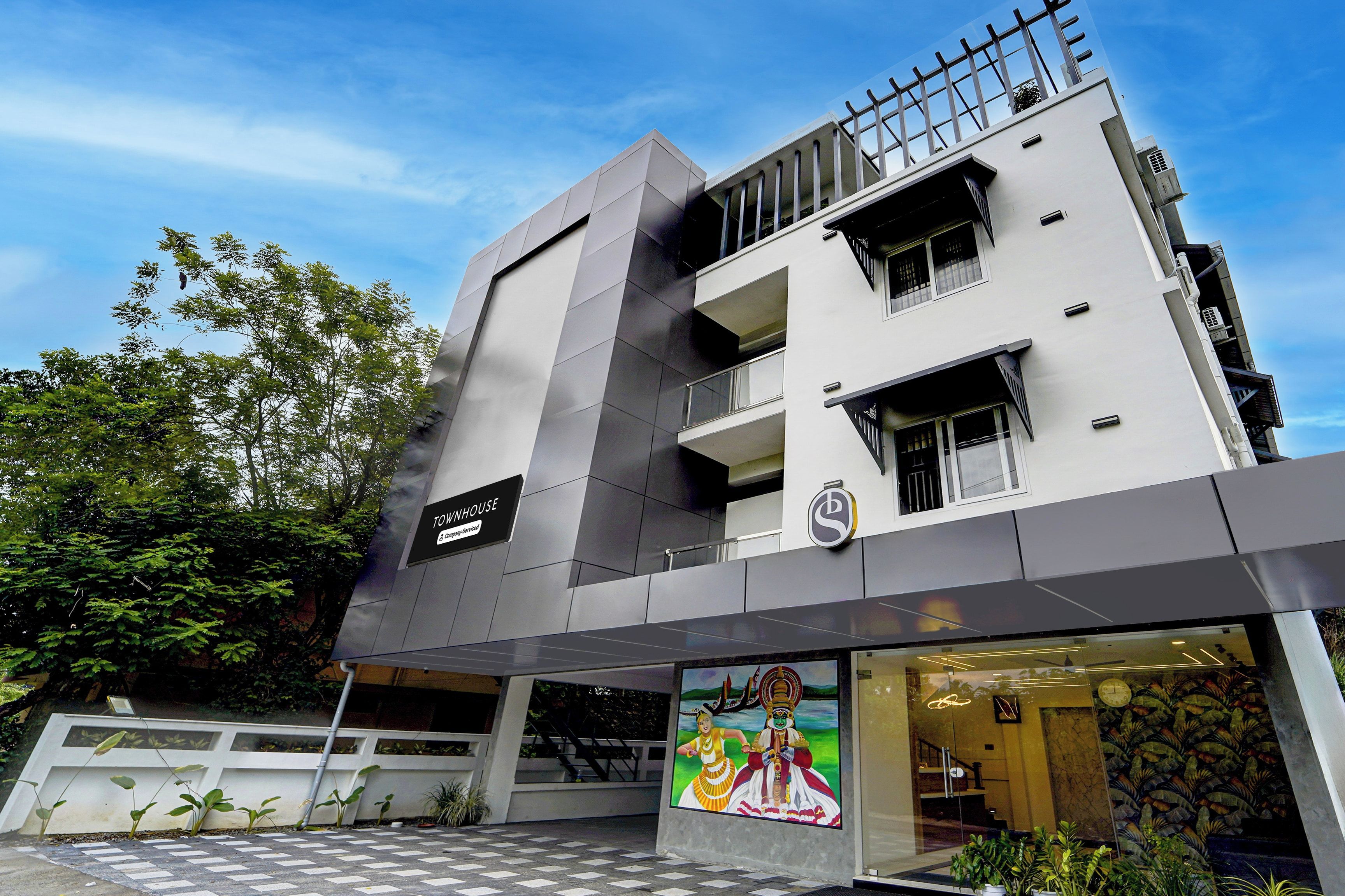Un edificio moderno con un suelo estampado en cuadros, un letrero que indica un servicio de la empresa y un mural con una escena cultural.