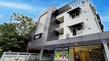 Un edificio moderno con un suelo estampado en cuadros, un letrero que indica un servicio de la empresa y un mural con una escena cultural.