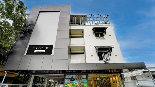 A modern building with a sign reading 'TOWNHOUSE Company-Serviced'.