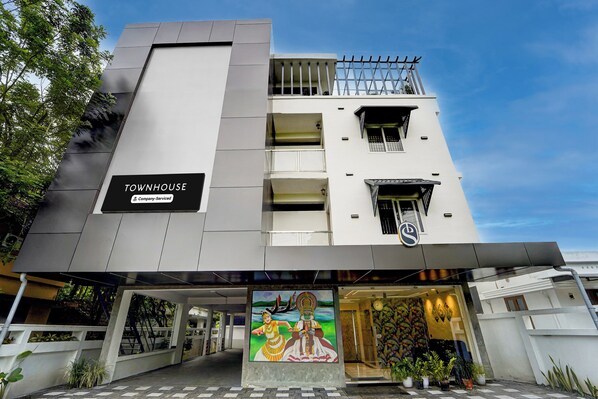 A modern building with a sign reading 'TOWNHOUSE Company-Serviced'.