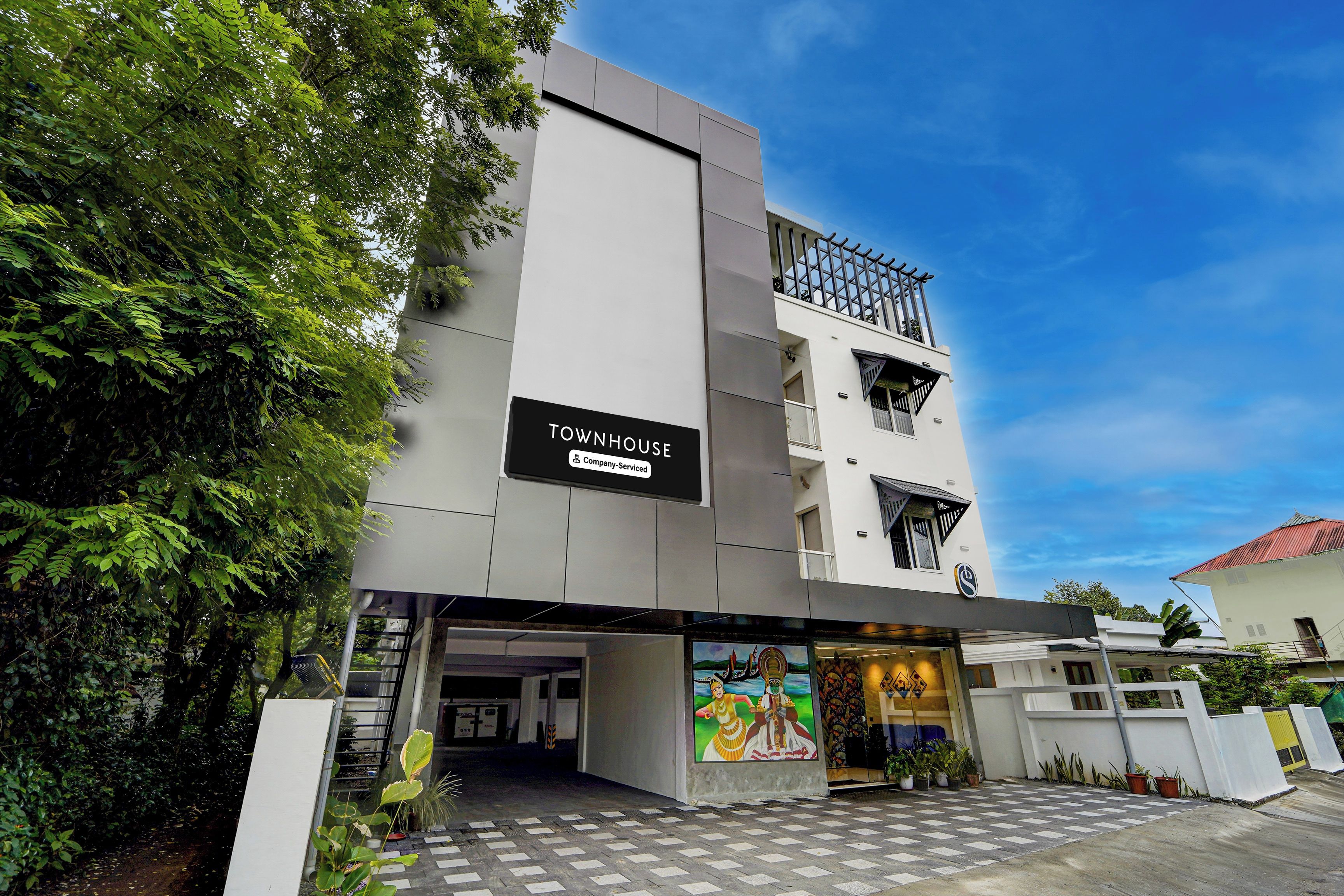 Un edificio moderno con un letrero que dice 'TOWNHOUSE' y 'Company Serviced'.