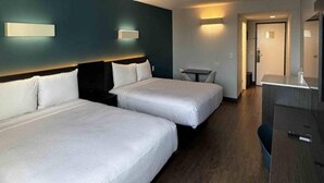 Een hotelkamer met twee bedden, een bureau en een klein tafeltje.