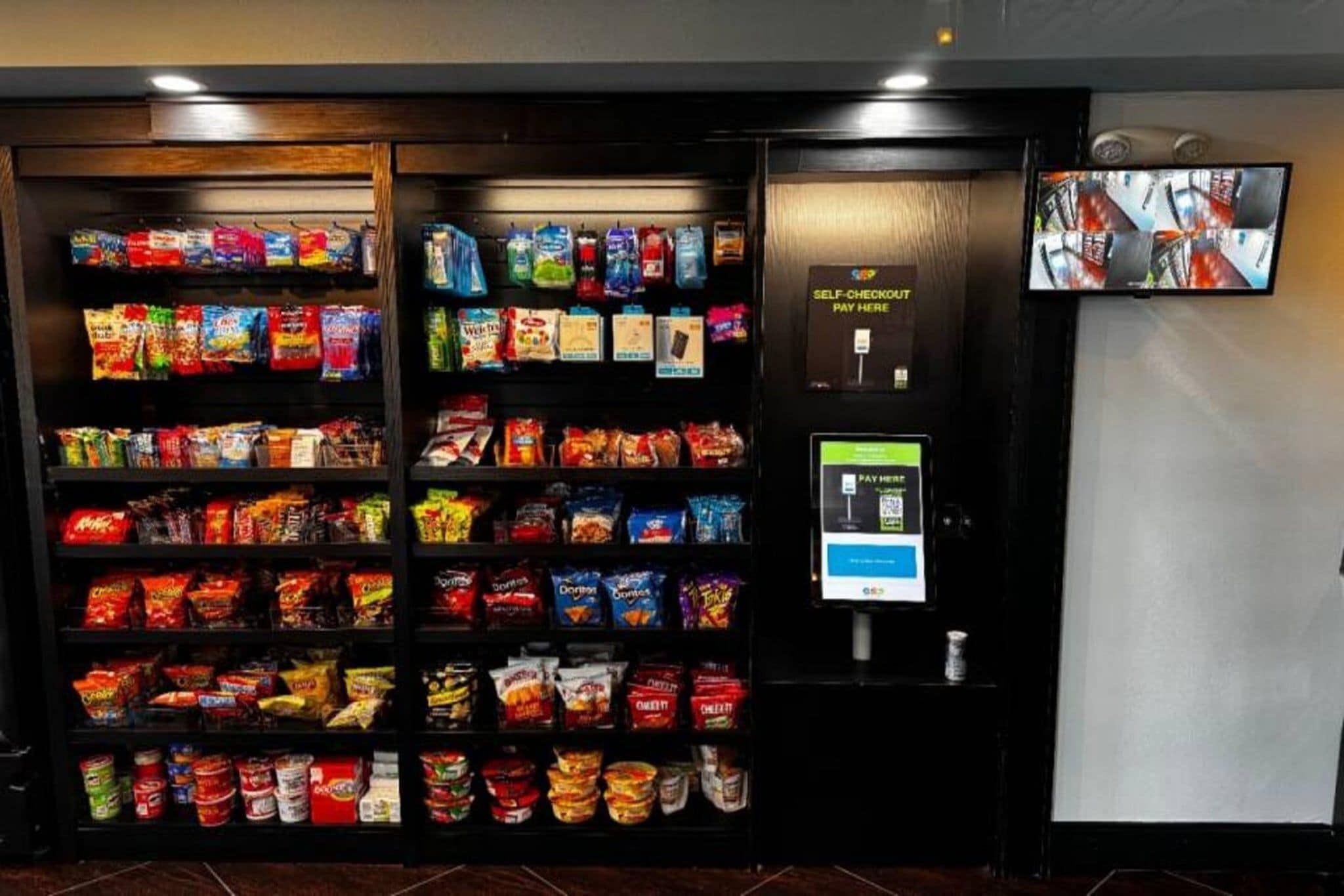 A self-checkout machine with a screen and payment terminal in a store.