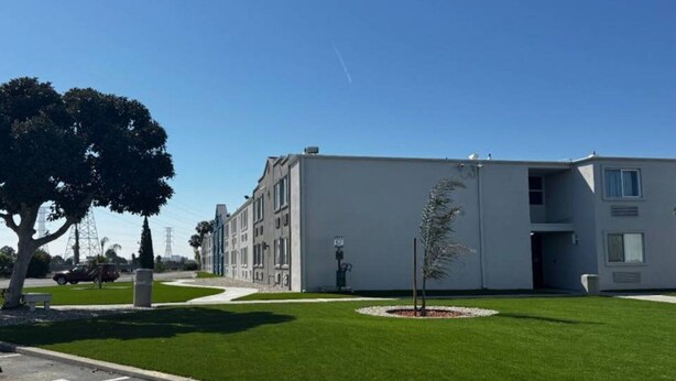 Een modern gebouw met een plat dak en een kleine boom in het midden.