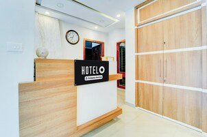 Mostrador de recepción de hotel con un letrero que indica servicio de empresa.