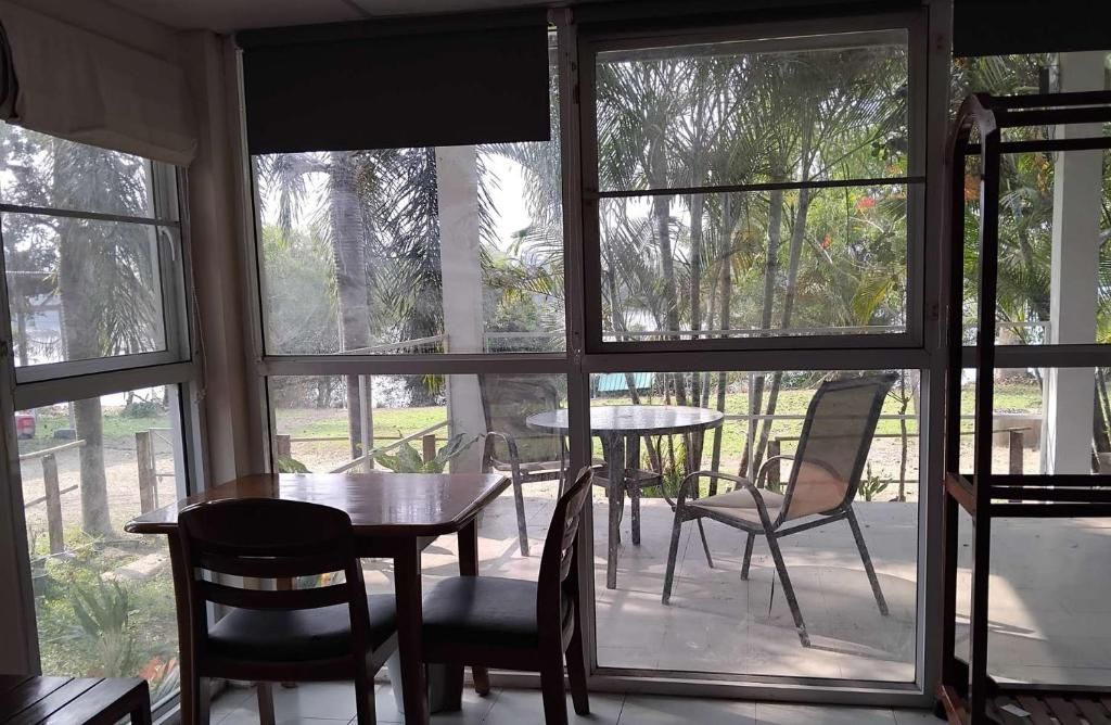 Une pièce avec une grande fenêtre, une table et des chaises.