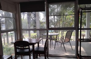 A room with a large window, a table, and chairs.