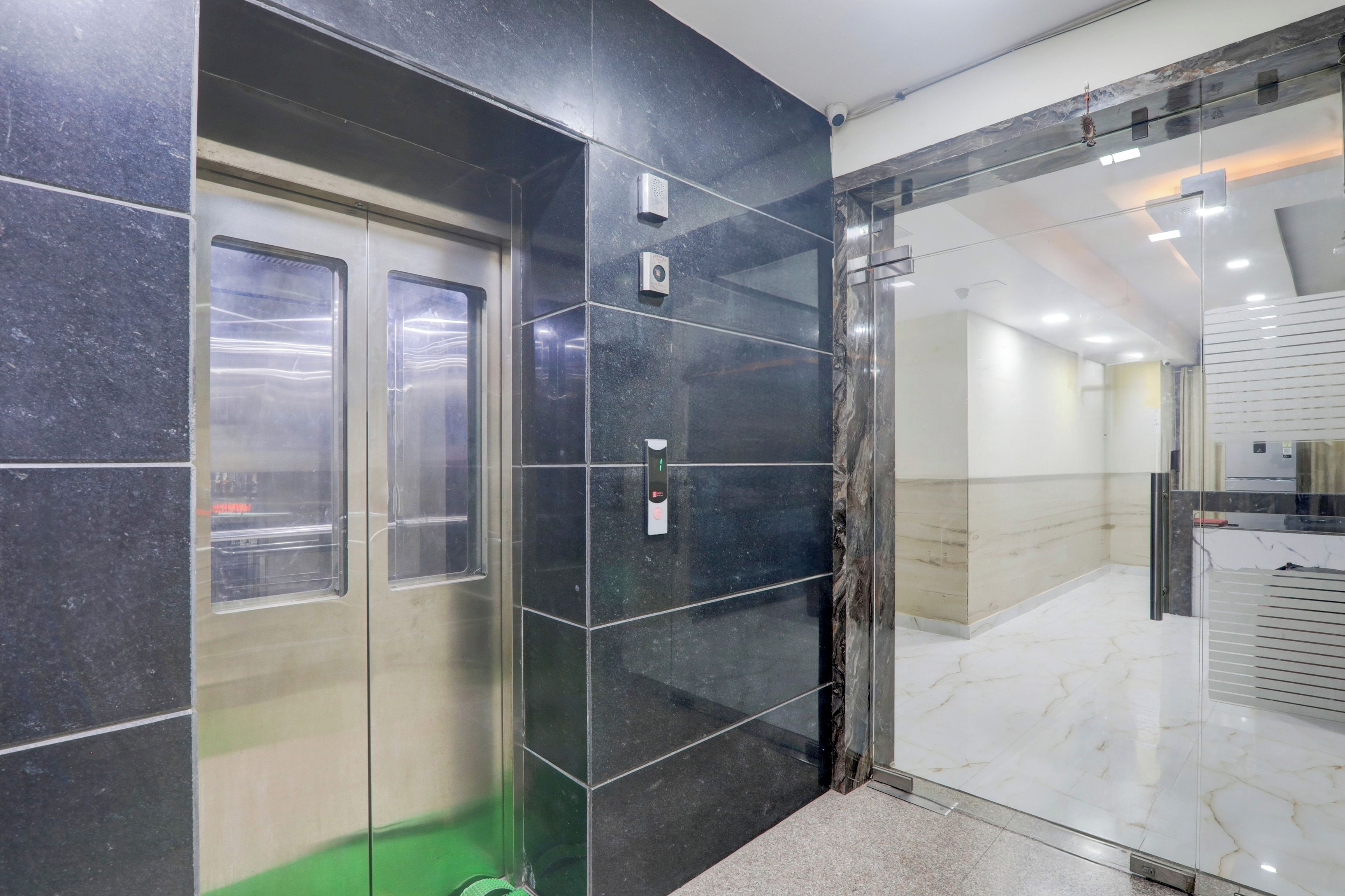 An elevator with a digital display and a glass door.